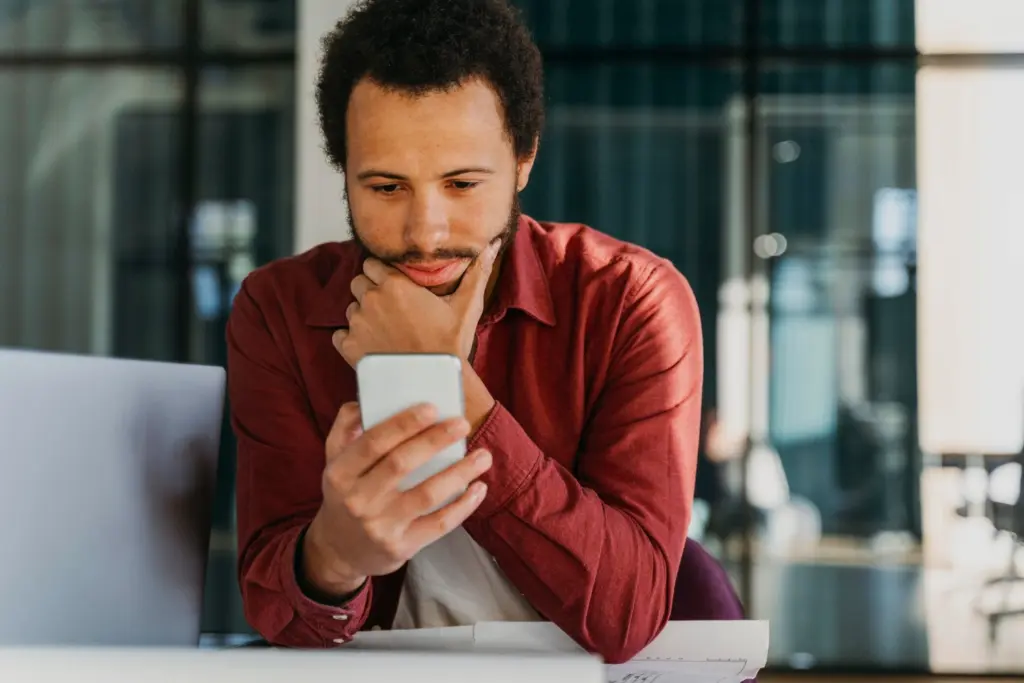 ragazzo osserva il telefono che ha in mano