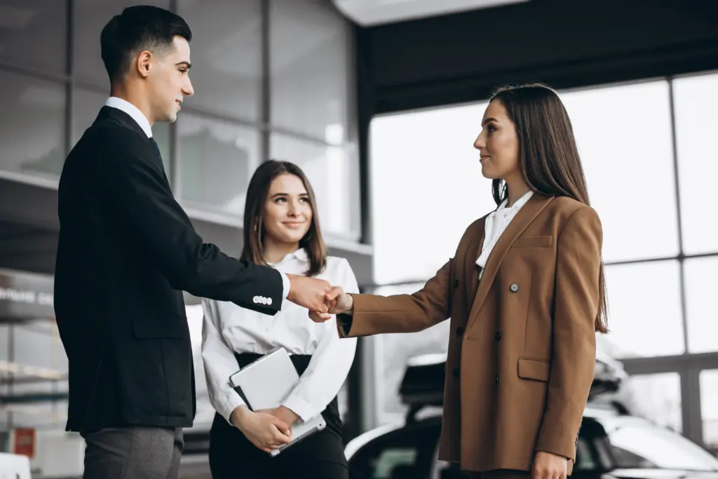 Come presentarsi ad un colloquio di lavoro Areajob - ragazzo stringe la mano a una ragazza e dietro di lui un'altra ragazza sorride