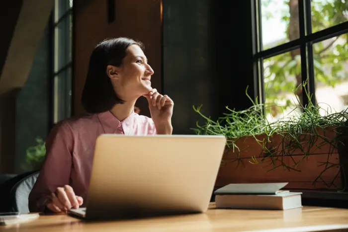 ragazze osserva fuori dalla finestra mentre lavor al pc