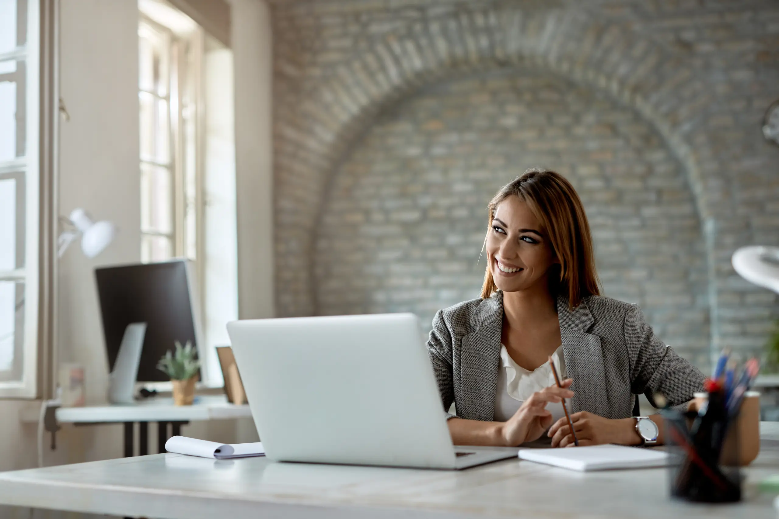ragazza sorridente in ufficio davanti al pc